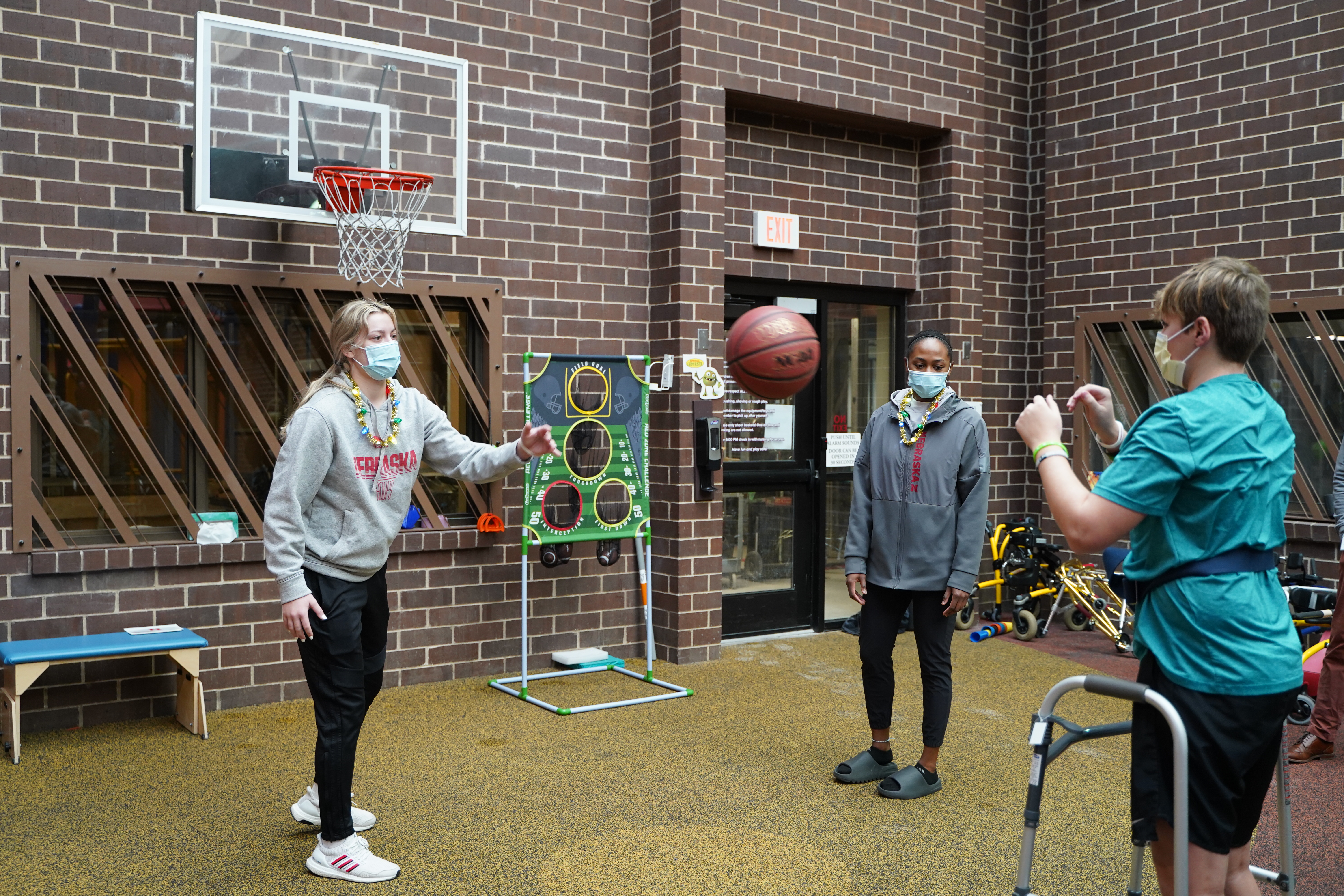 Cooper plays basketball with two Nebraska women's basketball players
